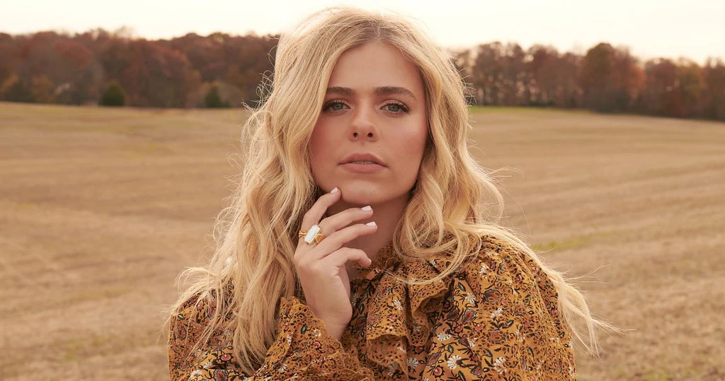 Elegant woman in patterned blouse outdoors, symbolizing hope and faith in God's promises for personal growth.