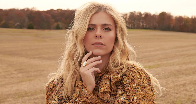 Elegant woman in patterned blouse outdoors, symbolizing hope and faith in God's promises for personal growth.