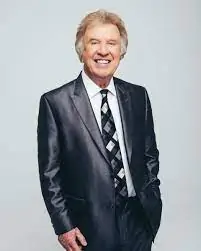 Handsome smiling man in suit and tie at a professional event.
