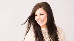 Optimistic young woman smiling with long dark hair, representing hope and promise.