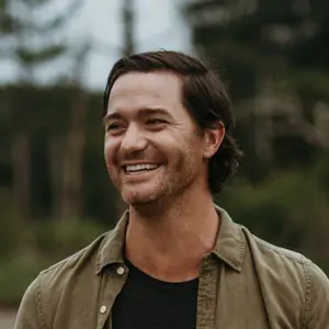 Hopeful man smiling outdoors at sunset, symbolizing trust and commitment in The Promise.