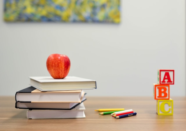 A school desk with an apple on top of books