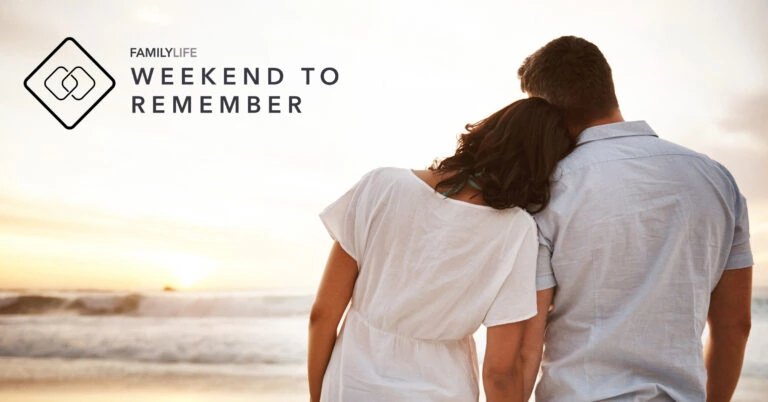 Relaxed couple walking on the beach at sunset, promoting the "Weekend to Remember" event.